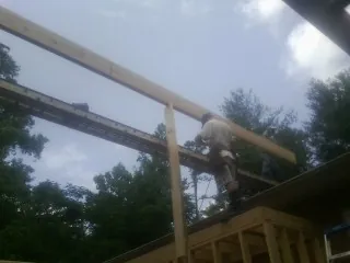 Carpenter setting a ridge beam over a new addition frame — Ice Dam Removal by Roofing Brothers in Potsdam