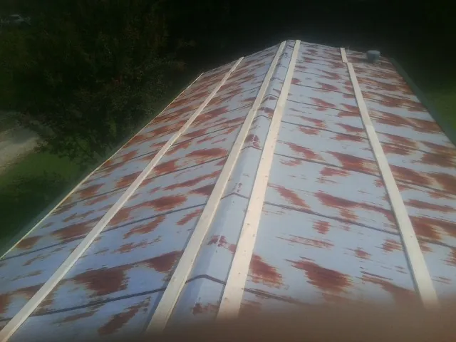 Rusted metal roof panels with new wood purlins before replacement — Storm Damage Roof Repair in Potsdam by Roofing Brothers